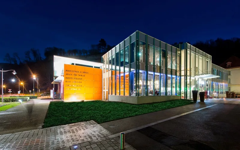 Night view of the modern glass entrance to Casino JOA d'Uriage