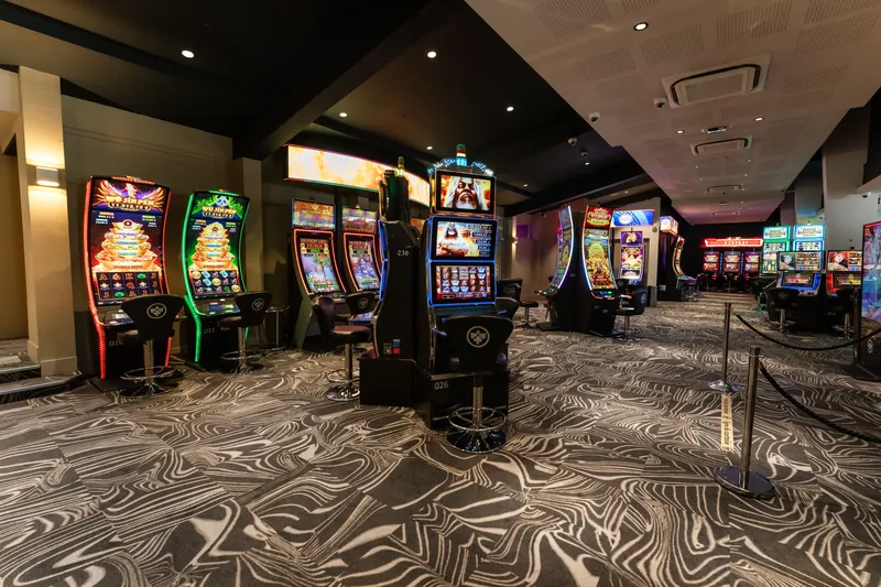 Carpeted gaming floor with slots at Casino JOA de Gérardmer