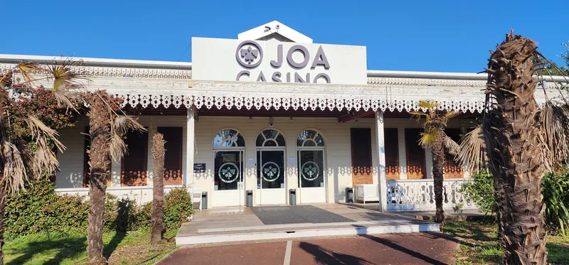 Front facade of Casino JOA de Gujan-Mestras framed by palm trees