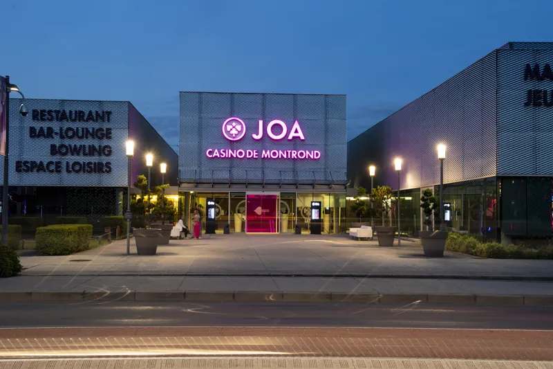 Pink-lit entrance facade of Casino JOA de Montrond-les-Bains