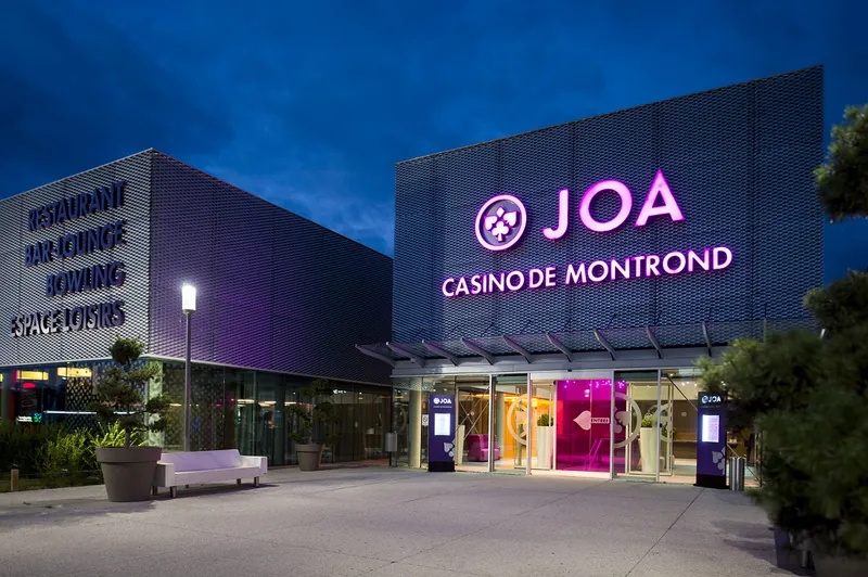 Illuminated main entrance to Casino JOA de Montrond-les-Bains at dusk
